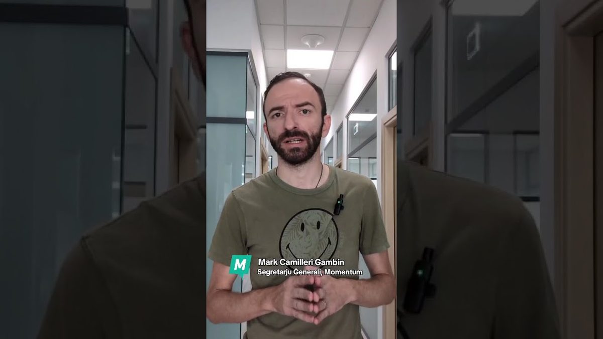 Video still of a man speaking in an office corridor, captioned as the secretary general of Momentum